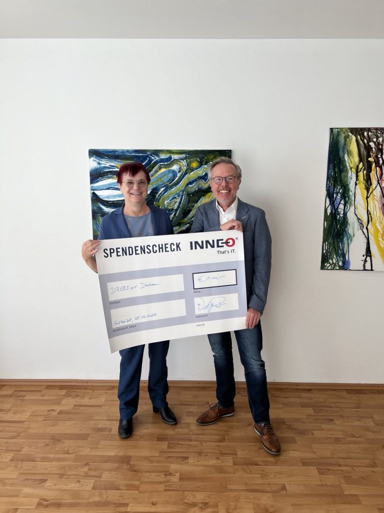 Zwei Männer halten einen Spendenscheck